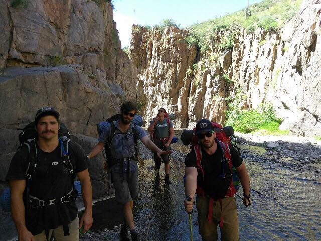 hiking through a river young men